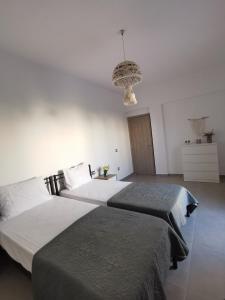 a bedroom with two beds and a chandelier at Mantalena's house in Antiparos
