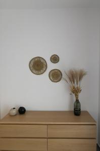 a wooden dresser with a vase with a plant on it at Mantalena's house in Antiparos