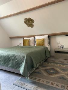 a bedroom with a bed with a green comforter at Hotel De Dampoort in Middelburg