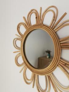 a round mirror with a wooden frame on a wall at Mantalena's house in Antiparos