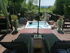 eine Whirlpool-Badewanne auf einer Terrasse in der Unterkunft The Forest House Krk 1 in Kras