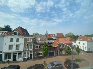een groep gebouwen met auto's geparkeerd op een parkeerplaats bij Hotel De Dampoort in Middelburg