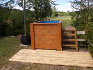 a wooden deck with a hot tub and a table at Agroturystyka u Wioli i Irka , domek u Ireny, spływy kajakowe in Karsin +1 photo