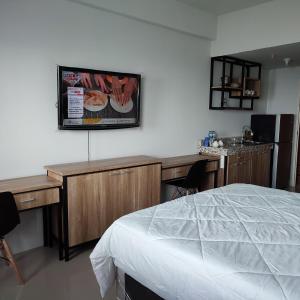 a bedroom with a bed and a desk with a sink at DeAr UC Apartment in Surabaya