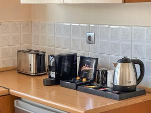 a kitchen counter with a coffee maker and a microwave at Mammis Studios in Kardamaina