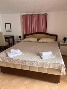 a bedroom with a bed with two towels on it at Apartments Radulovic in Sutomore