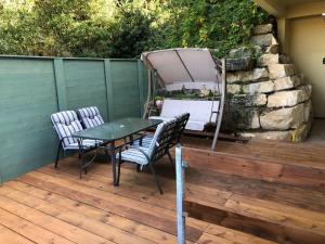 a patio with a table and chairs on a deck at צימר ספא in Kefar Weradim