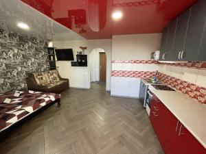 a kitchen and living room with a couch in a room at Studio apartment on Vatutina in Vinnytsya