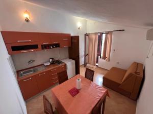 a kitchen and dining room with a table and a couch at Apartments Radulovic in Sutomore