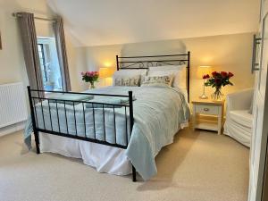 Un dormitorio con una cama grande y una ventana en Parsonage House, Badminton en Great Badminton