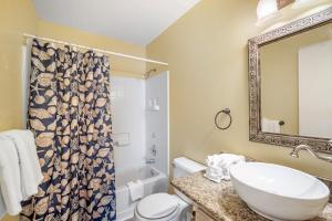 a bathroom with a sink and a toilet and a shower curtain at Coral Breeze by ALBVR - Pet Friendly 3BR, 2BA Beach House - Just Steps to the Beach in Fort Morgan +24 photos