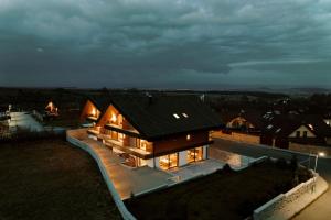 uma casa com um telhado preto com luzes em Villa Greystone em Nová Lesná