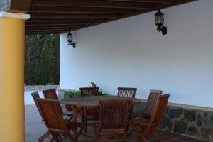 a wooden table and chairs on a patio at Casa Rural El Escondite in Ronda