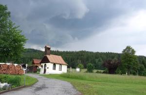 uma pequena casa branca na berma de uma estrada em Erlebnisbauernhof Sternhof em Bodenmais