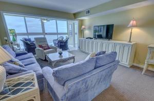 een woonkamer met blauwe banken en een televisie bij Edgewater West 53 by ALBVR - This Beachfront Condo is Perfect for your next Family Getaway in Gulf Shores