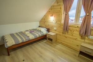 um pequeno quarto com uma cama e uma janela em Fenix em Žabljak
