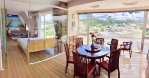 a dining room with a table and chairs and a bedroom at Starview Villa Dalat in Da Lat
