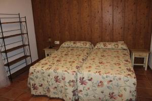 a bedroom with a bed and a wooden wall at Casa Rural El Escondite in Ronda