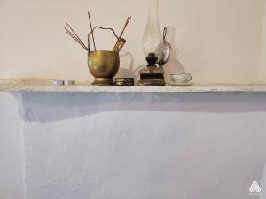 a shelf with vases and other items on it at stone house / Evdilos Icaria (-50%) in Akamatra