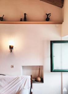 a bedroom with a bed and a window and a shelf at stone house / Evdilos Icaria (-50%) in Akamatra