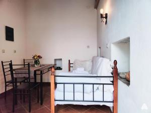 a bedroom with a bed and a table with a tableablish at stone house / Evdilos Icaria (-50%) in Akamatra
