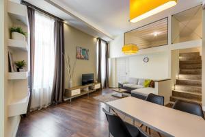Spacious & stylish apartment in downtown Budapest في بودابست: غرفة معيشة مع طاولة وكراسي وأريكة