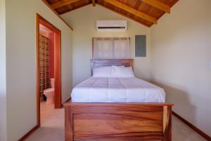 - une chambre avec un lit et une tête de lit en bois dans l'établissement Cottage 5 at Island Pearl Gold Standard Certified, à Caye Caulker