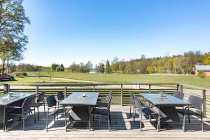 un gruppo di tavoli e sedie su una terrazza con campo di Bruksgården Bed&Breakfast a Undenäs