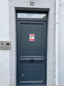 een blauwe deur met een bord erop bij La Bâtisse de Chabot N°7 in Montluçon
