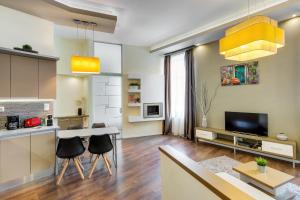 uma cozinha e sala de estar com mesa e cadeiras em Spacious & stylish apartment in downtown Budapest em Budapeste