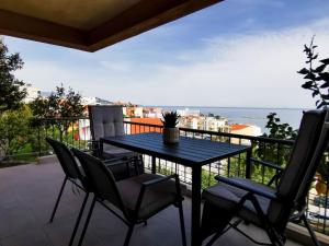 a table and chairs on a balcony with a view of the ocean at Armonia Petra House in Kavála