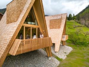 un grupo de personas de pie en el balcón de un edificio en Collis Hill, en Kals am Großglockner