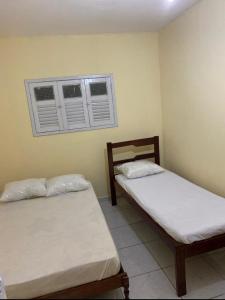 zwei Betten in einem Zimmer mit zwei Fenstern in der Unterkunft Apto Temporada in Campina Grande