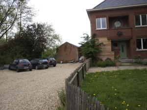 ein Haus mit Autos, die vor einer Einfahrt geparkt sind in der Unterkunft B&B Halen in Halen