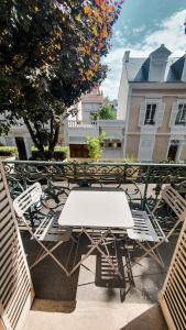 uma mesa branca e cadeiras em frente a um edifício em Appartement T3 à deux pas du centre-ville em Vichy
