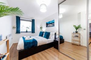 sypialnia z dużym łóżkiem z niebieskimi poduszkami w obiekcie Perfect for Long Stays Business & Family Guests! Stratford London Sleeps 6 Guests! WIFI & Netflix w Londynie