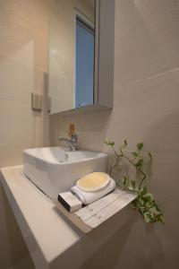 ein Badezimmer mit einem weißen Waschbecken und einem Spiegel in der Unterkunft Karat Home in Ho-Chi-Minh-Stadt