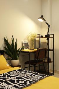 einen Schreibtisch mit einer Lampe und einem Stuhl in einem Zimmer in der Unterkunft Karat Home in Ho-Chi-Minh-Stadt
