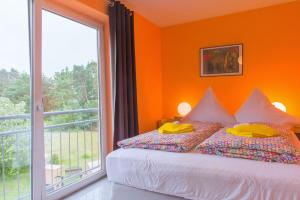 オストゼーバート・ゼリンにあるHaus Maxiのオレンジ色の壁のベッドルーム(ベッド1台、窓付)