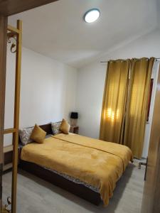 een slaapkamer met een bed en een geel gordijn bij Apartments Orhidelia Njivice in Njivice