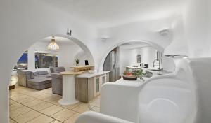 cocina y sala de estar con paredes blancas y un arco en Paraga Villa1 "7min WALK TO BEACH" by Calypso Sunset Villas, en Mykonos ciudad