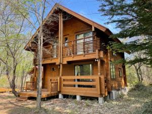 a large wooden cabin in the woods with trees at HARUNA CABIN - Vacation STAY 62249v in Tsumagoi