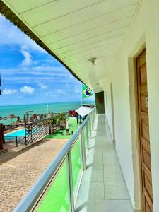 a balcony with a view of the beach and the ocean at Pousada Alto do Cruzeiro in Maragogi