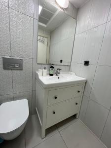 a bathroom with a sink and a toilet and a mirror at Lara Kundu Oteller Bölgesi in Aksu