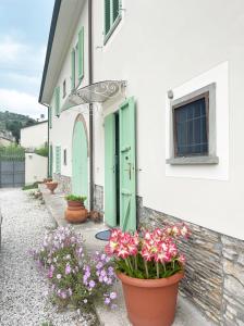 a building with a green door and some flowers at 'Il Casale di Giova' Tuscan Farmhouse in Lucca