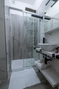 bagno con doccia in vetro e lavandino di DOMORA BEDROOMS a Ortona