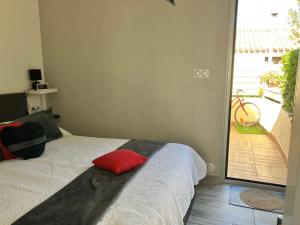 Un dormitorio con una cama con una almohada roja. en Naturiste Heliovillage Villa de Standing, en Cap d'Agde