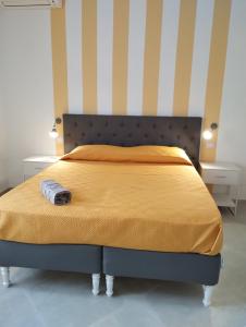 a bedroom with a bed with a yellow blanket and two night stands at Monti d'aMare in Agerola