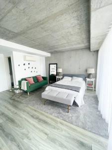 ein Schlafzimmer mit einem großen Bett und einem grünen Sofa in der Unterkunft * Blanc Studio Aveiro * in Aveiro