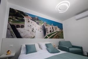1 dormitorio con una foto de un castillo en la pared en DOMORA BEDROOMS, en Ortona